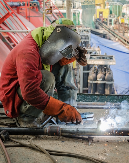 welder worker welding metal at construction site