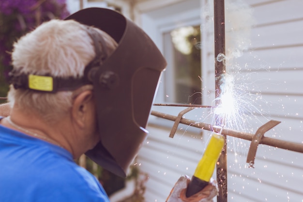 Welding worker repairing metal construction