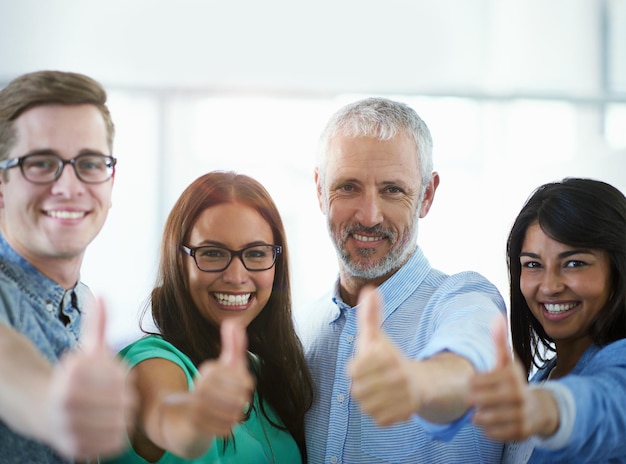 Well get the job done Cropped portrait of a group of businesspeople giving the thumbs up