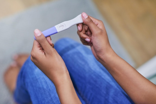 Well this is a surprise Shot of an unidentifiable woman holding a pregnancy test while sitting in her bathroom