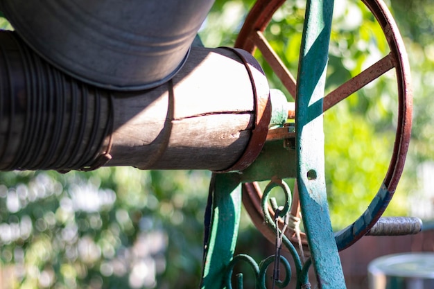 A well with a bucket in a European village Sunny day Metal bucket for a water well Detail of a well