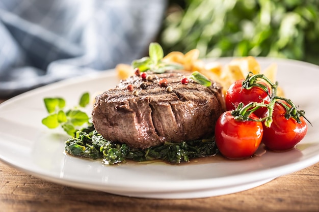 Welldone steak served with veggies on a plate ready to be eaten