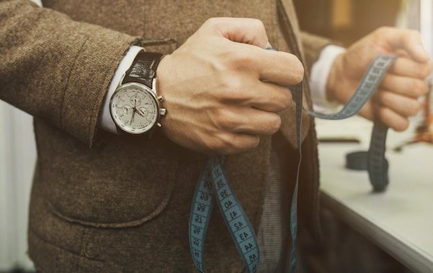 Welldressed tailor holds a measure in his hands craftsman selfemployed