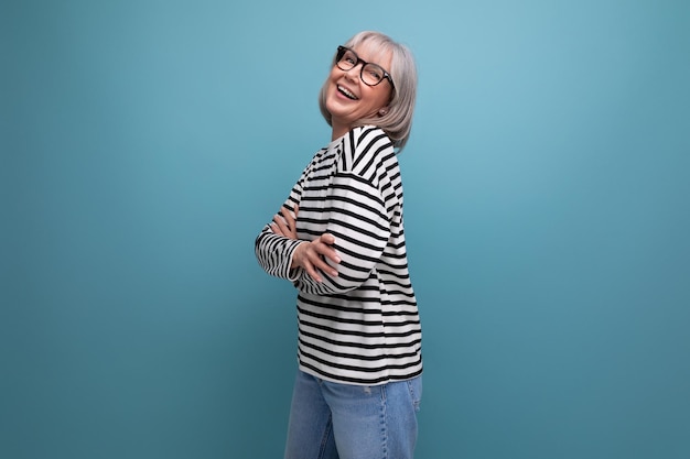 A wellgroomed middleaged woman in a fashionable image is flirting on a bright studio background