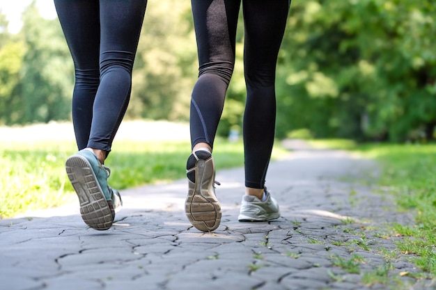 Wellness and fitness concept low angle view of running women in the park on a sunny morning