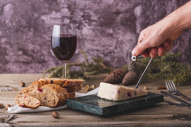 Wensleydale cheese with cranberries red wine honey nuts raisins on marble cutting board Black concrete background Selective focus