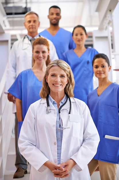 Were here to take care of you Portrait of a diverse team of medical professionals standing on a staircase in a hospital