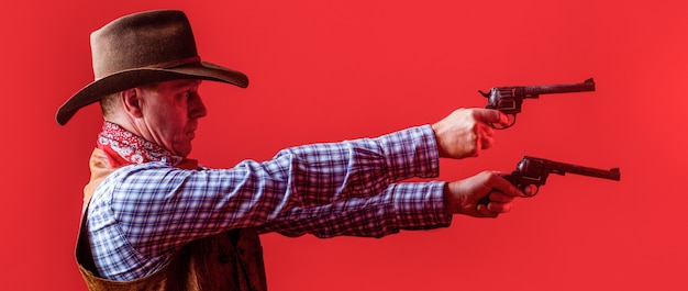 West, guns. Portrait of a cowboy. Western man with hat. Portrait of cowboy in hat. Man wearing cowboy hat, gun. Portrait of a cowboy.