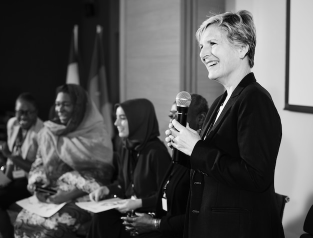 A Western Business Woman Speaking into a Microphone 