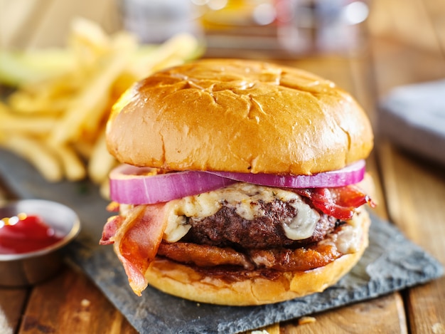 Western style bacon burger with onion rings and bbq sauce