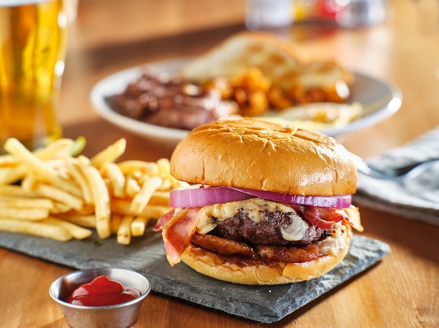 Western style bacon burger with onion rings and bbq sauce