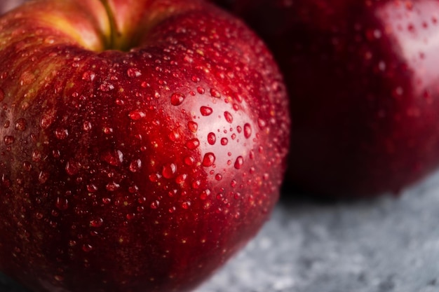 Wet and juicy fresh red apples with water drops on dark background with. Close-up. Selective focus