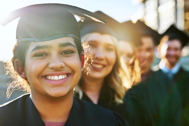 Weve been eagerly anticipating this day Portrait of a group of students standing in a line on graduation day