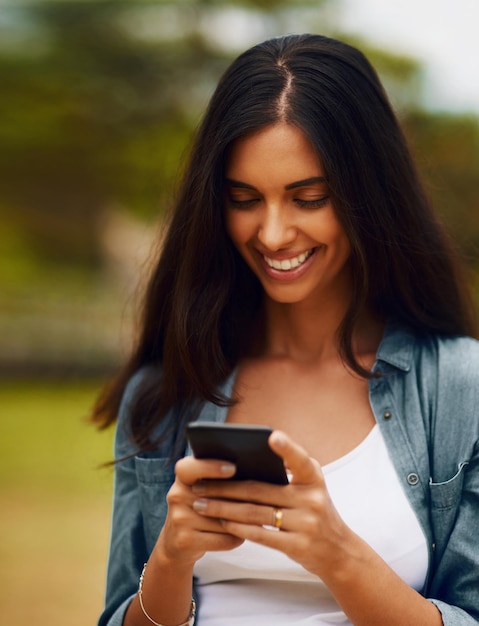 Whats everyone else up to this weekend Shot of an attractive young woman using a mobile phone in a park