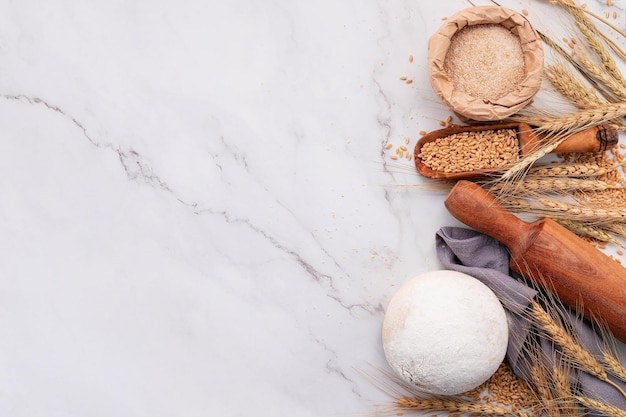 Wheat ears and wheat grains set up on marble background Top view and copy space