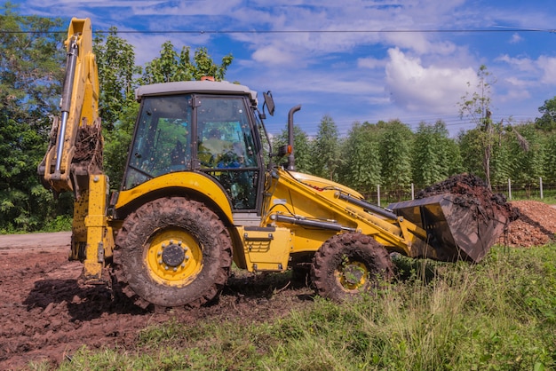 Wheel loader Excavator with backhoe loading soil at construction site.