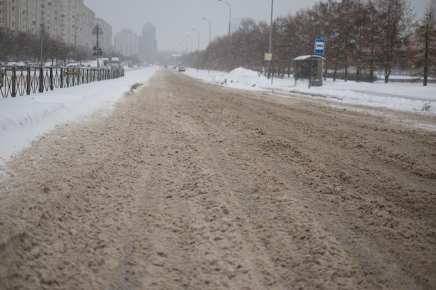 Wheel tracks on mud. Snow on dirty soil with car wheel tracks. Dirty melting snow on the road.