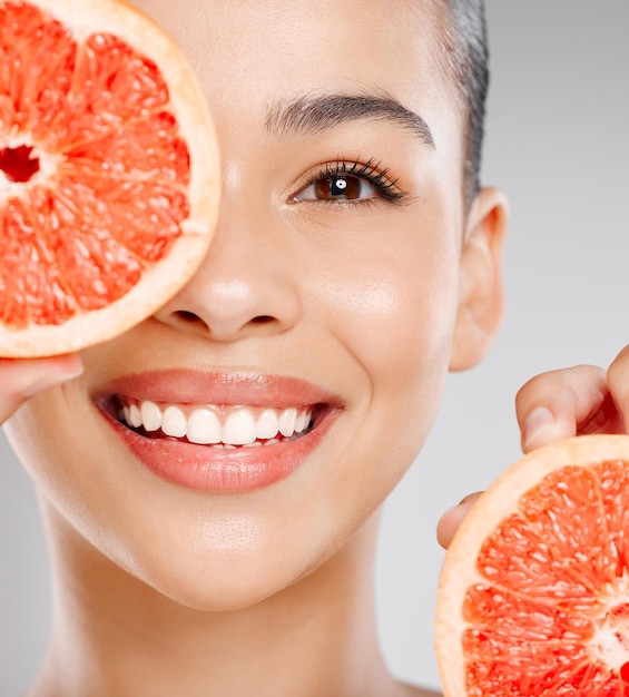 Where would my skin be without vitamin c Studio shot of an attractive young woman holding grapefruit to her face against a grey background