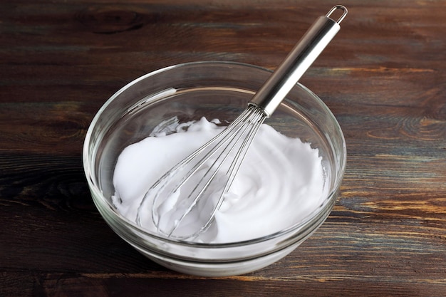 Whipped egg whites for cream on wooden background