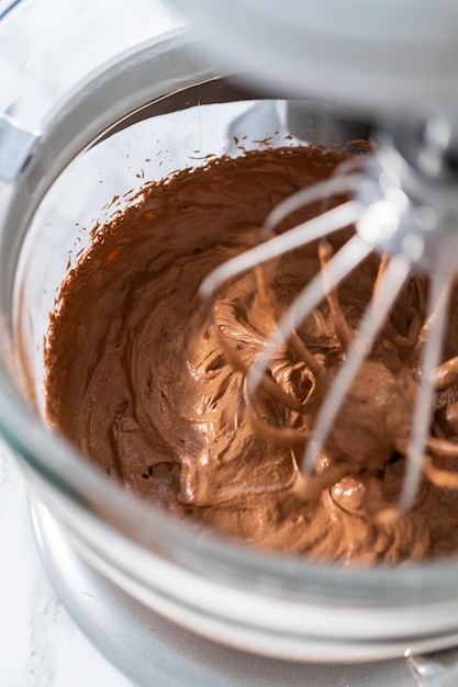 Whipping chocolate ganache with an electric kitchen mixer.