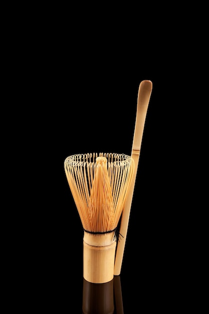 Whisk chasen and bamboo spoon chashaku on black background Set for making matcha tea