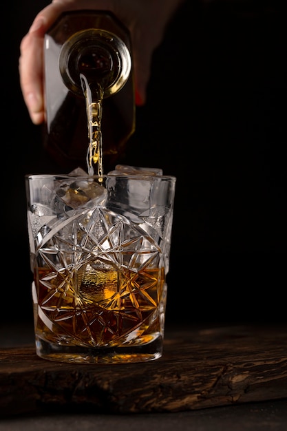 Whiskey or cognac is poured into an old fashioned glass