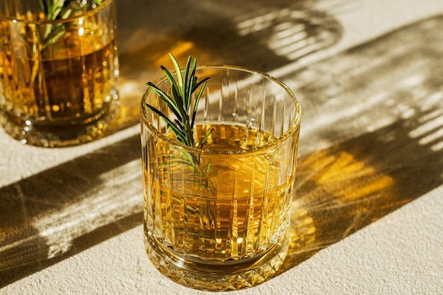 Whiskey in two glasses decorated with rosemary