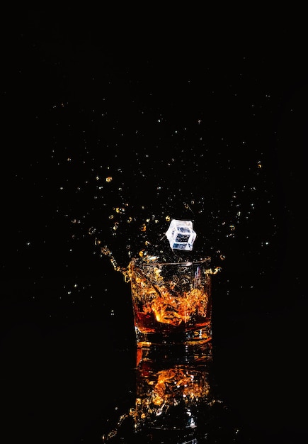 Whiskey with splash on black background