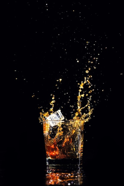 Whiskey with splash on black background