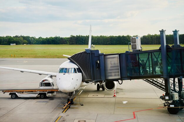 Photo white airplane being prepared for boarding at the airport gate