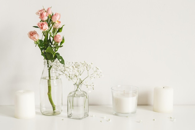 White arrangement of roses babys breath flowers and candles Copy space for lettering