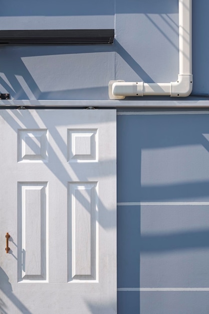 White artificial wooden door with air conditioner pipeline of gray prefabricated street kiosk