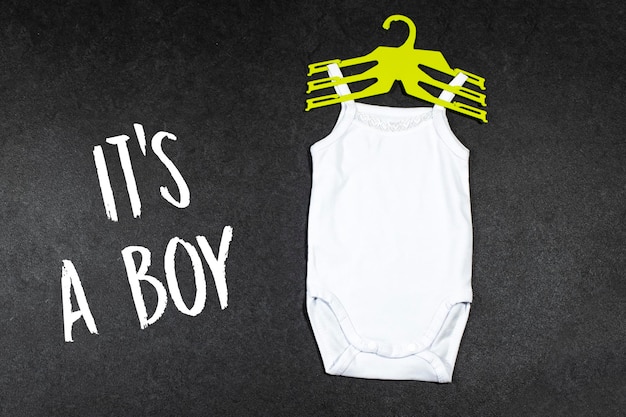 White baby girl or boy bodysuit mockup flat lay with its boy text on grunge gray concrete backgroun