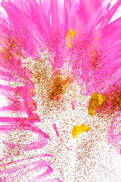 Photo on a white background pink streaks of watercolor are sprinkled with gold sparkles