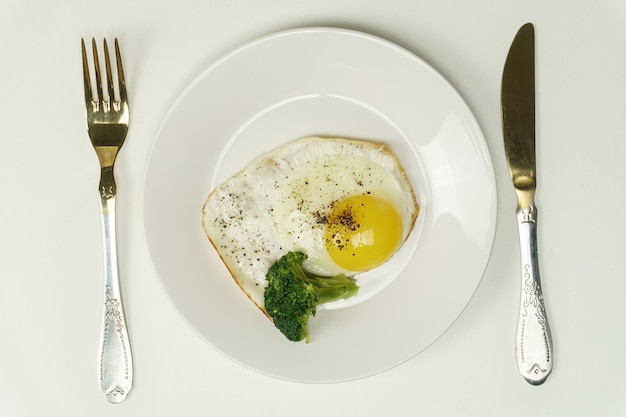 On a white background a plate with a fried egg