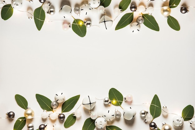 A white background with a frame of pearls and green leaves and decorations