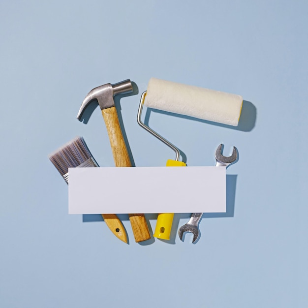 Photo white banner with copy space over a selection of hand tools in a repairs, maintenance, diy or renovations concept over a square blue background