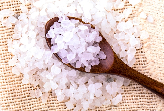 White bath salt in a wooden spoon closeup