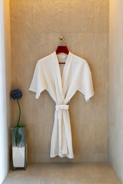 white Bathrobe hanging on wall in bathroom