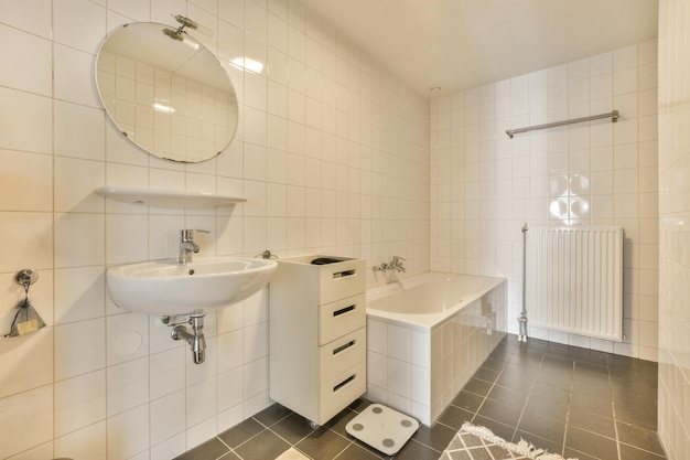 a white bathroom with black tile flooring and wall mounted mirror above the sink in the room is very clean