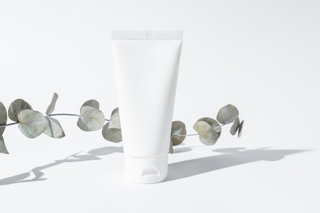 white beauty cream lotion spf sunscreen cosmetic in tube packaging Product mockup with eucalyptus branch in sun daylight facial skin care healthcare