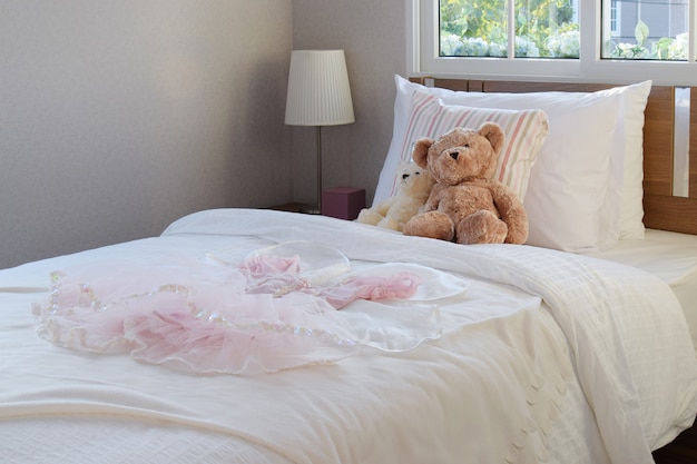 White bedroom decorative with pillows and dolls on bed