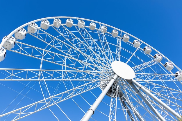 White big ferris wheel against blue sky bottomup view