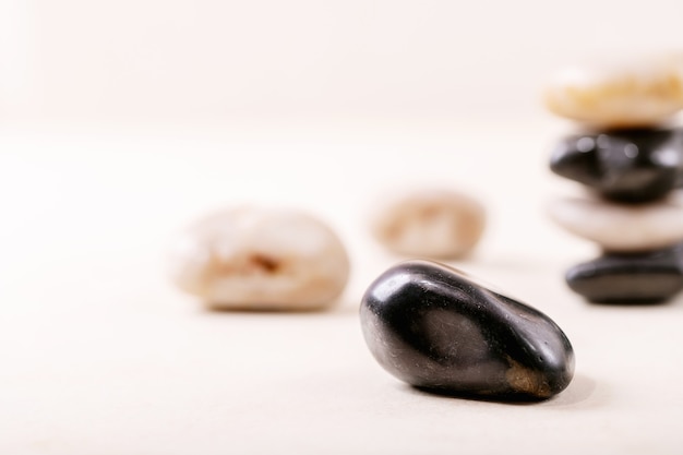 White, black decorative rocks and pebbles over grey wooden background