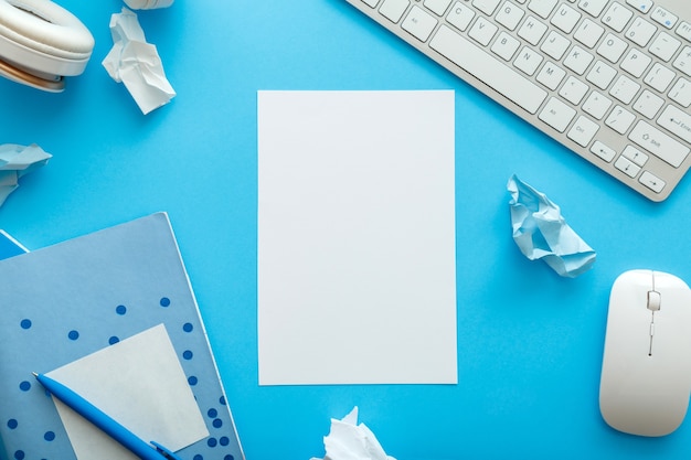 White blank mockup for copy space with frame made from office and school white blue stationery on pastel blue layout for work and education. Back to school concept. Blue desk workspace. Flat lay.