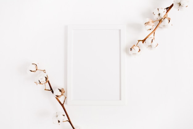 White blank photo frame mock up and cotton branches on white