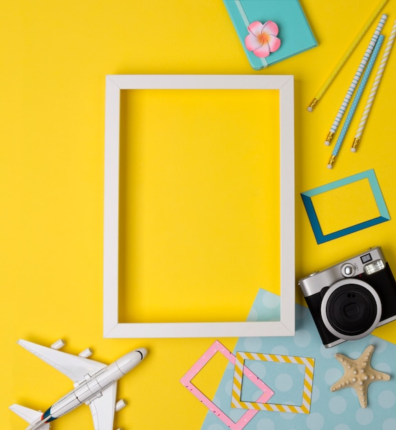 White blank photo frame with camera, plane, starfish, pencils