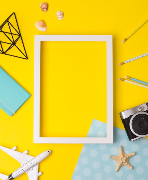 White blank photo frame with camera, plane, starfish, pencils