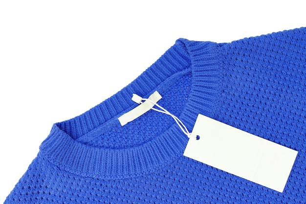 White blank rectangular clothing tag on blue knitted sweater isolated on white background