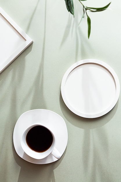 White blank round and square photo frames and white cup of black coffee